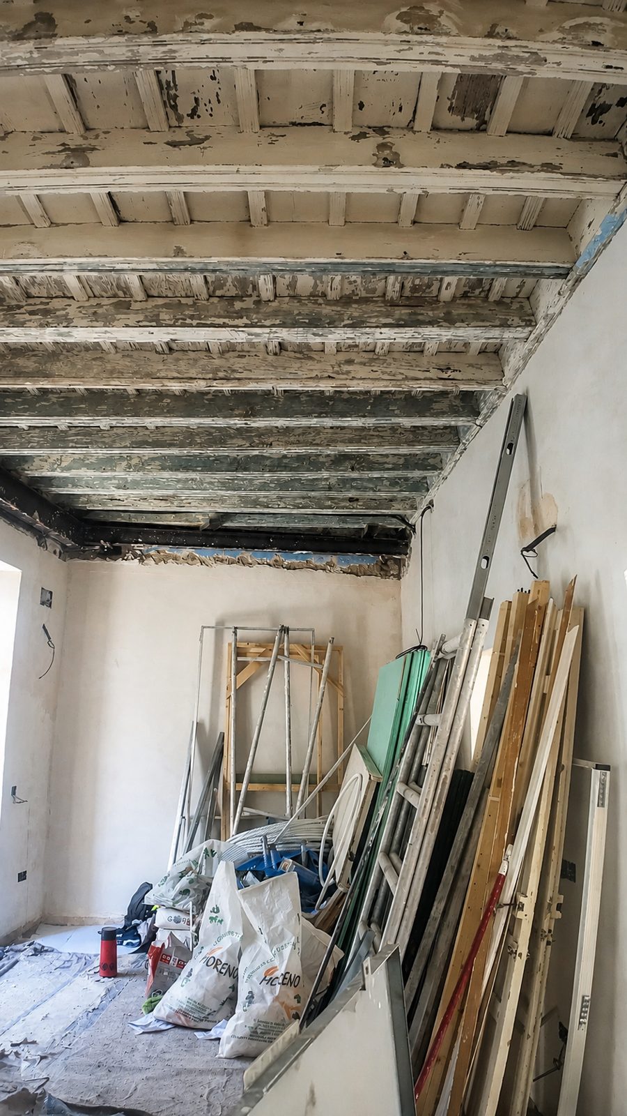 Vigas de madera a la vista, con el material de la obra.